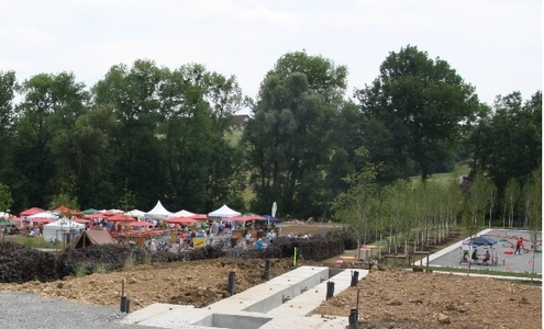 Im Vordergrund ist eine Baustelle zu sehen, im Hintergrund sind Pavillons und Sonnenschirme des Limesaktionstagessowie eine Sportfläche zu erkennen.