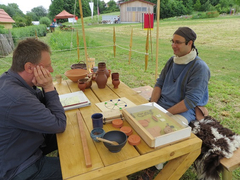 Zwei Teilnehmer der römischen Schautruppe aus Öhringen spielen ein Brettspiel.